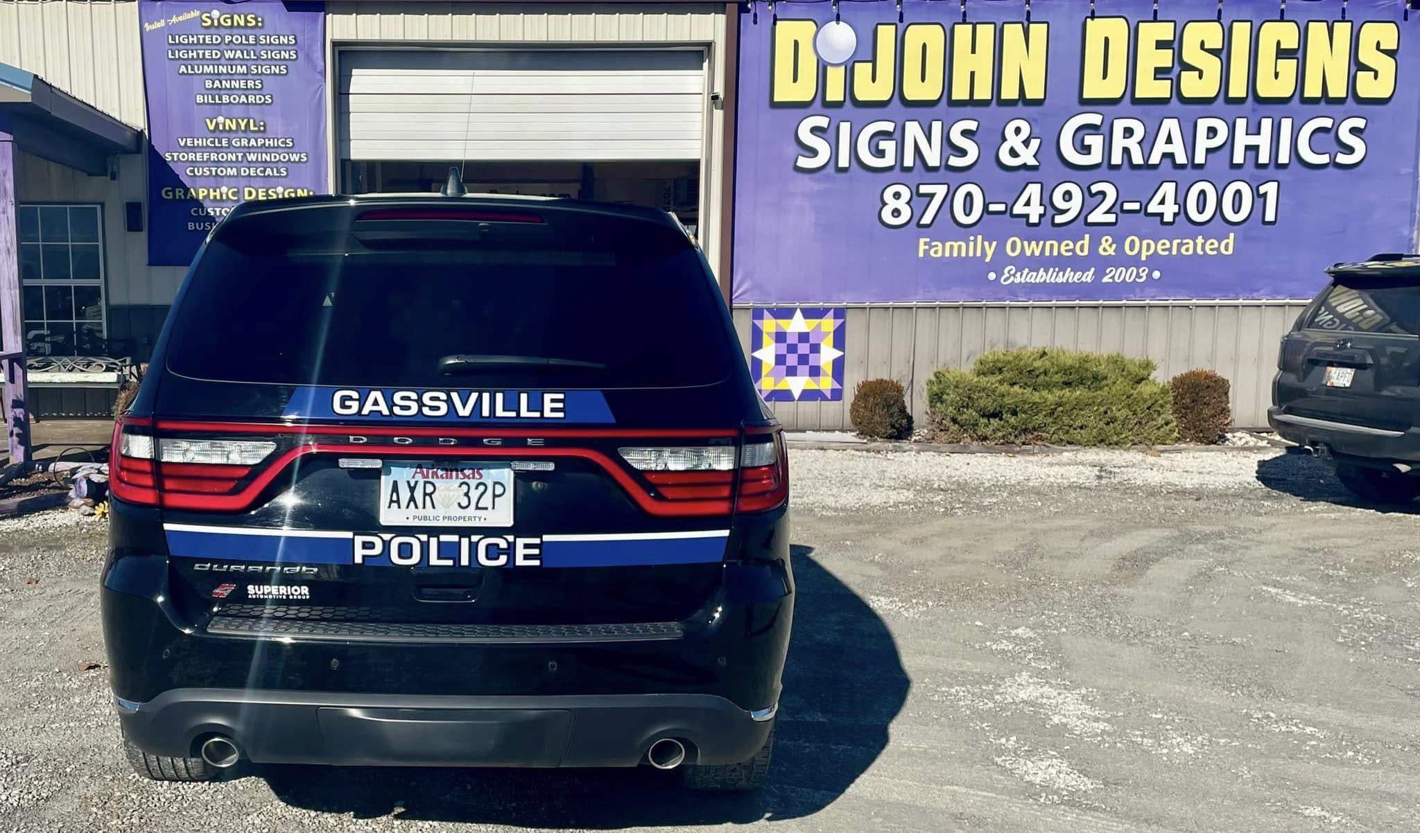 Gassville Police Department vehicle with blue and white stripes and lettering on the rear.