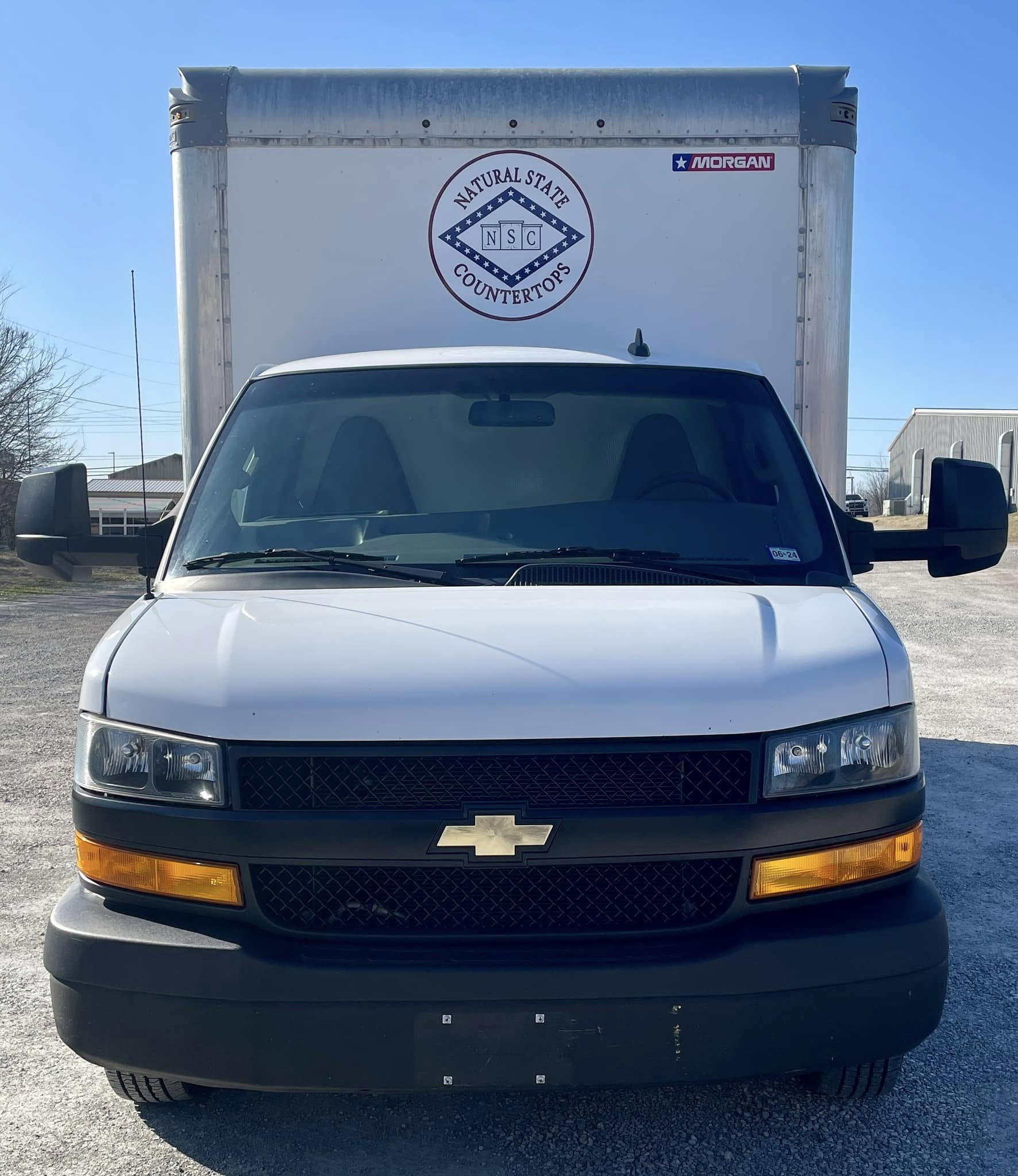 White box truck with circular Natural State Countertops logo on the back