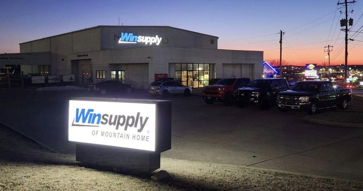 Lighted monument sign and dimensional letter building sign for Winsupply of Mountain Home at dusk