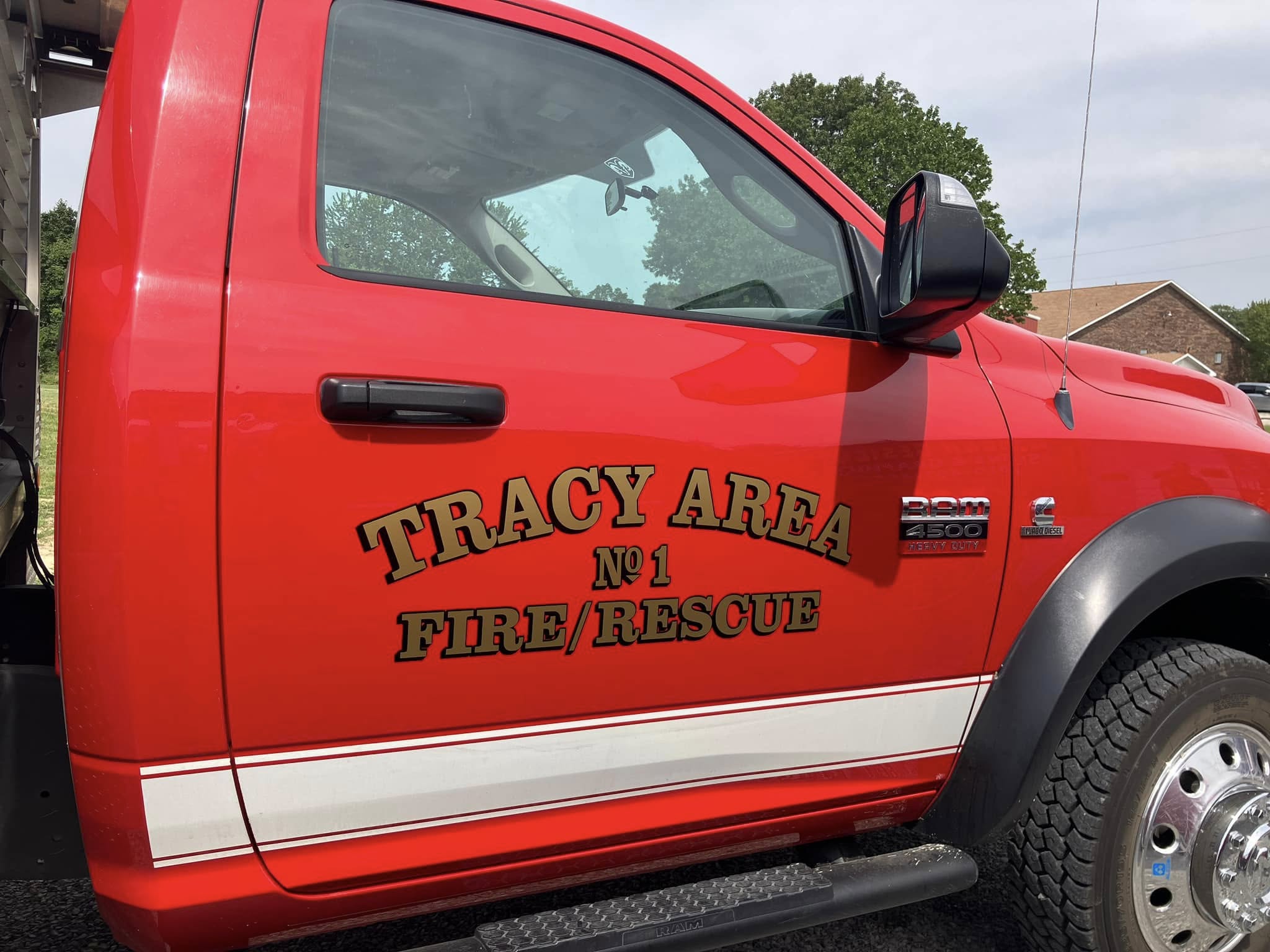 Custom gold and black vinyl lettering and white stripes on a red fire/rescue truck.