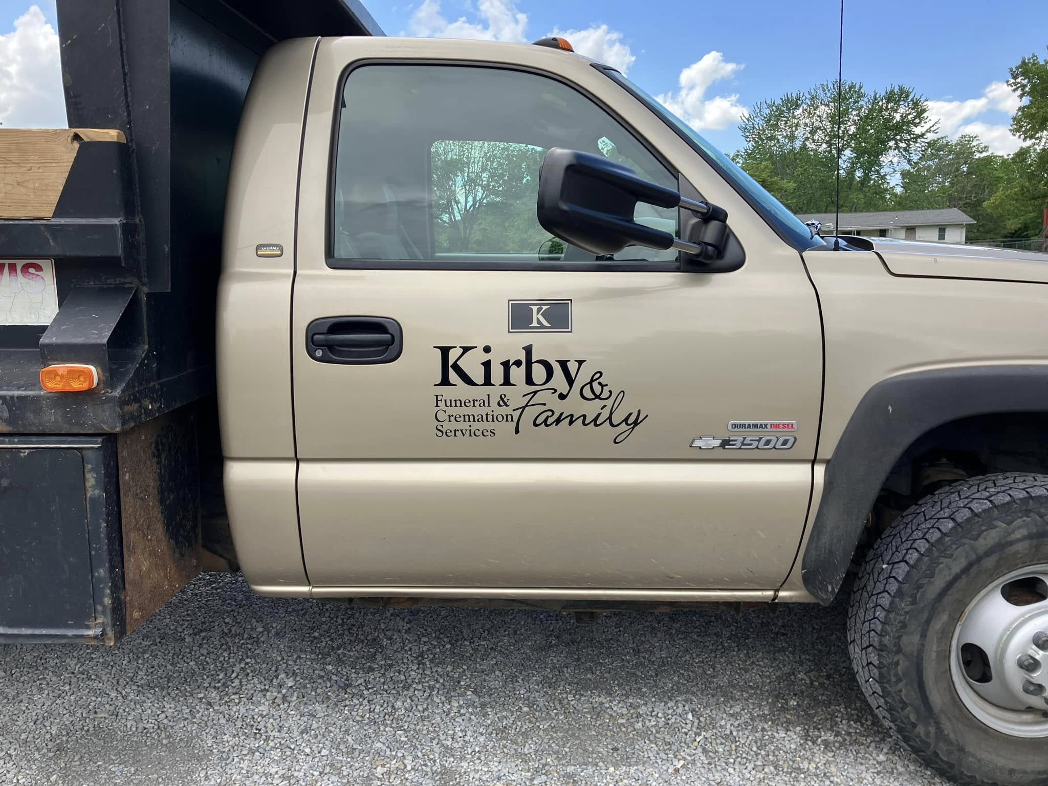 Custom vinyl decals on golden-tan dump truck for Kirby & Family Funeral & Cremation Services