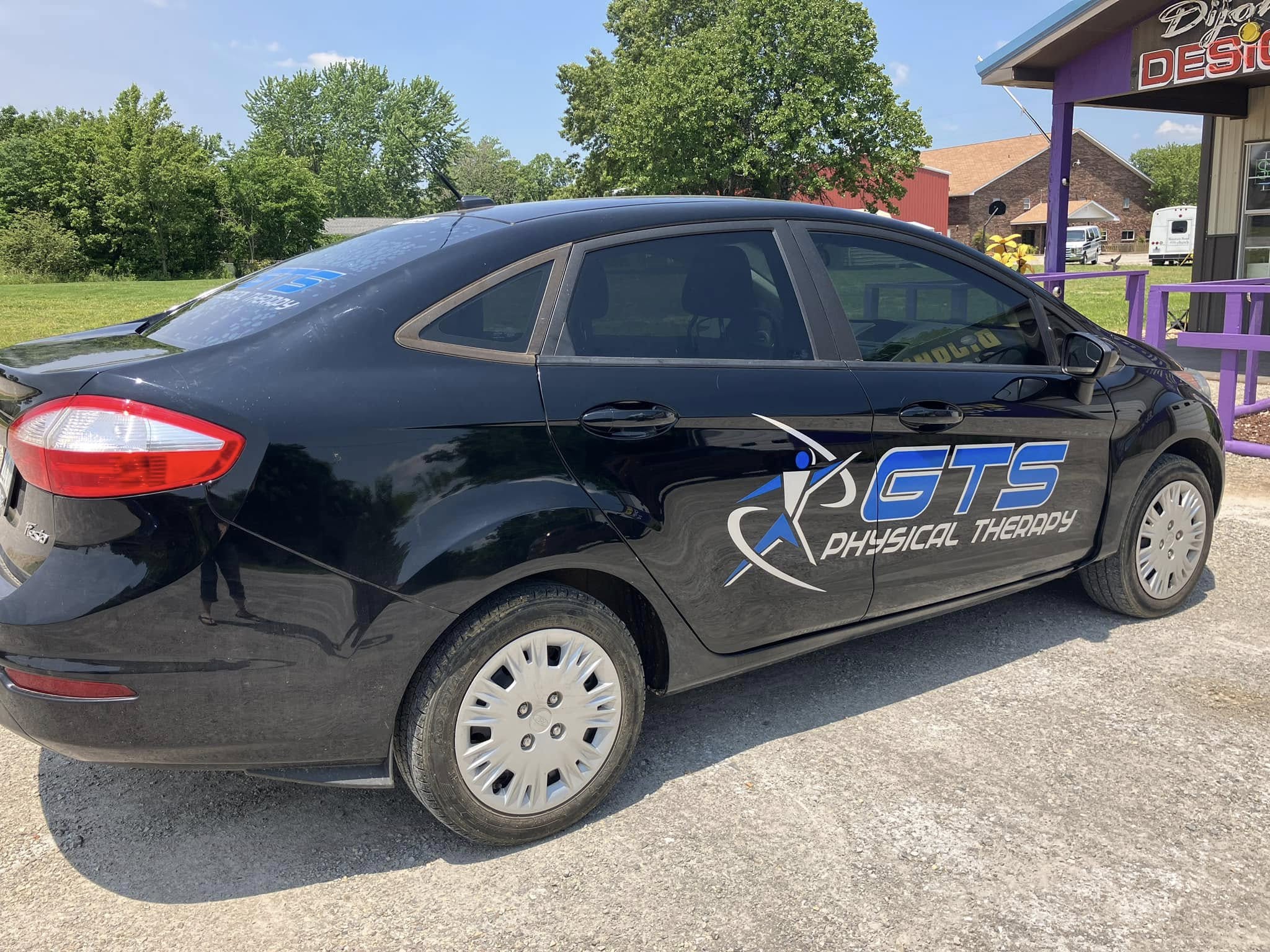 Custom vinyl graphics for GTS Physical Therapy on a black Ford Fiesta