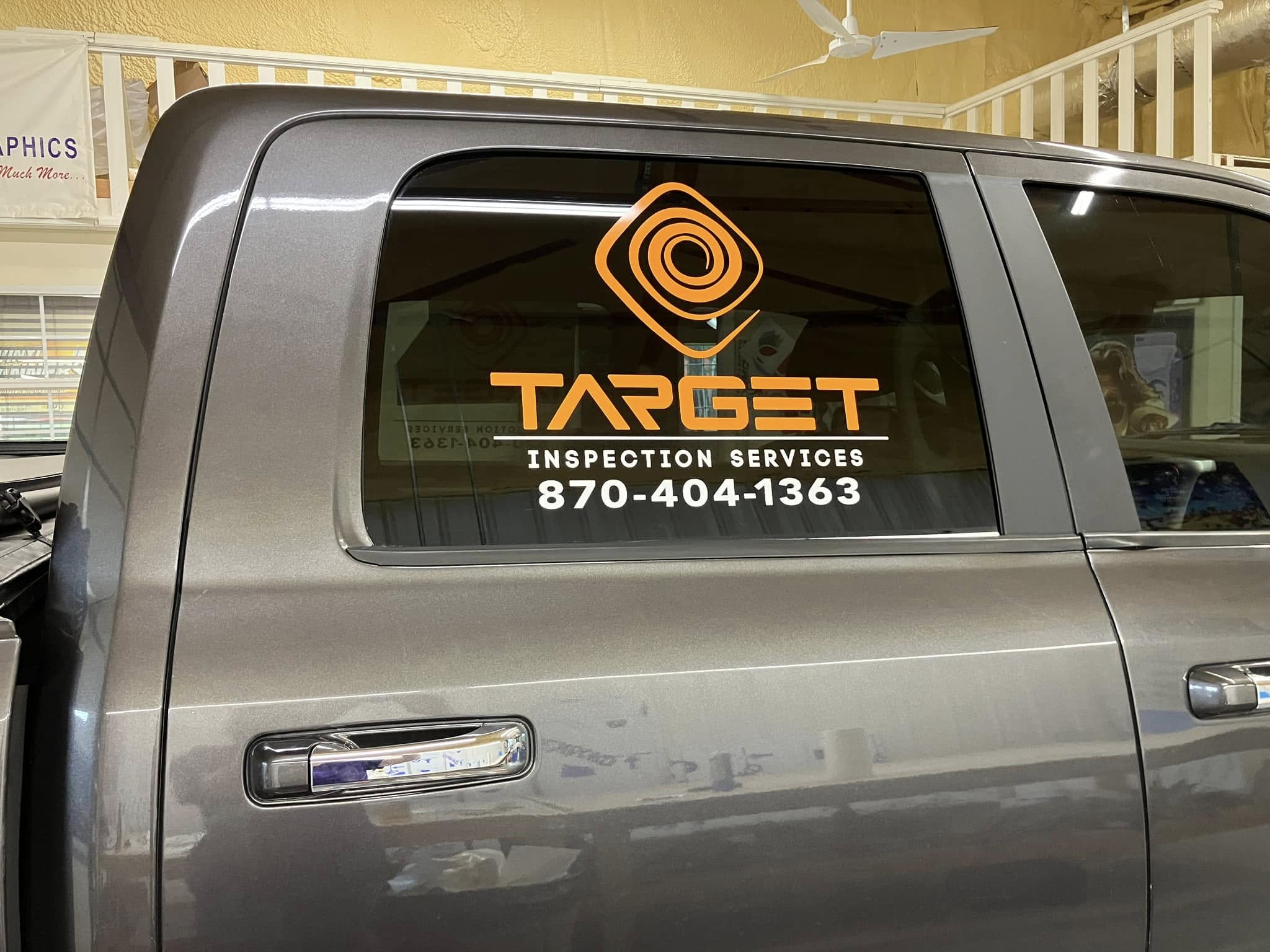Orange and white vinyl graphics on a gray truck window for Target Inspection Services