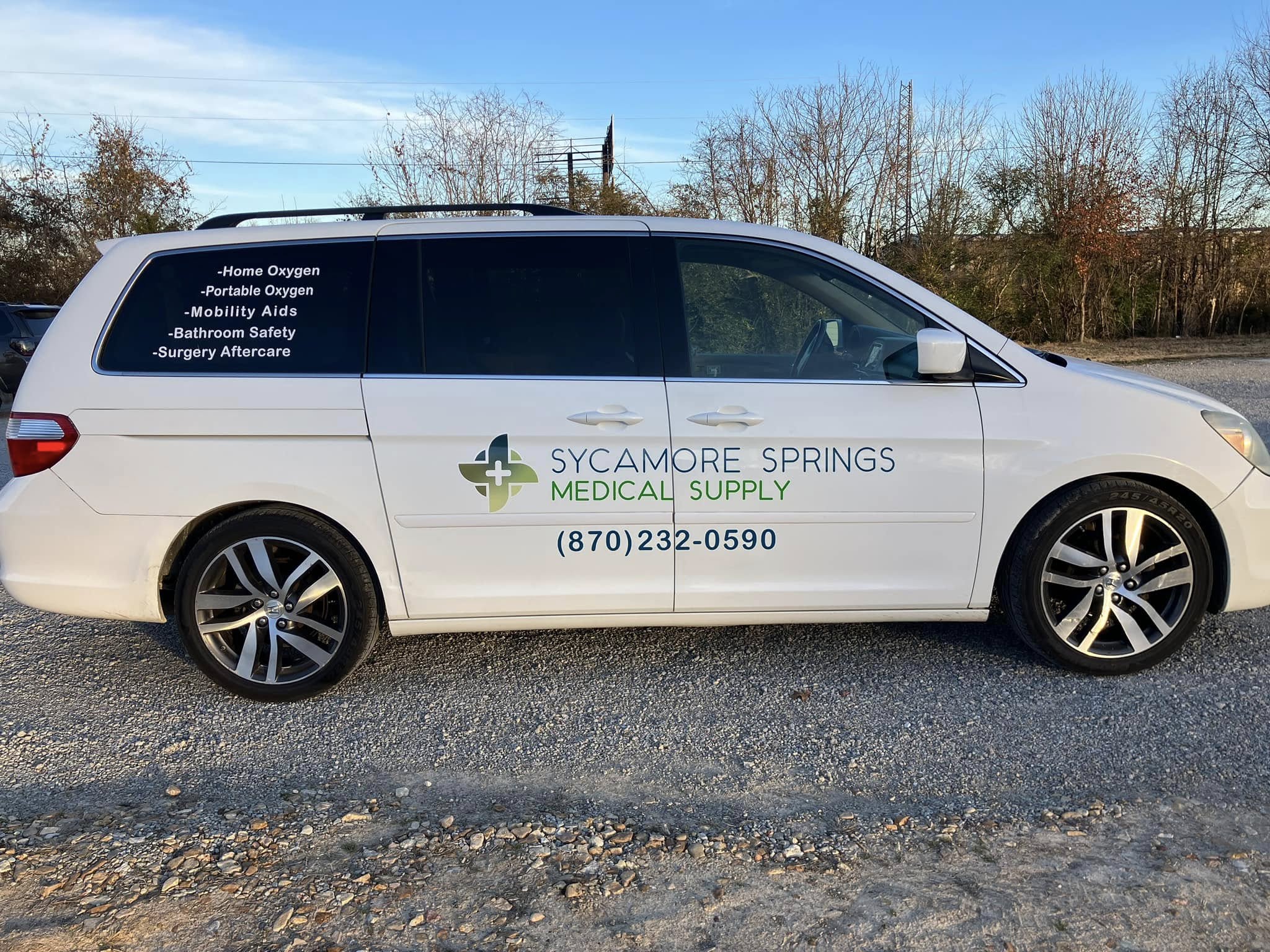 White minivan with vinyl graphics for Sycamore Springs Medical Supply, detailing services like oxygen and mobility aids.