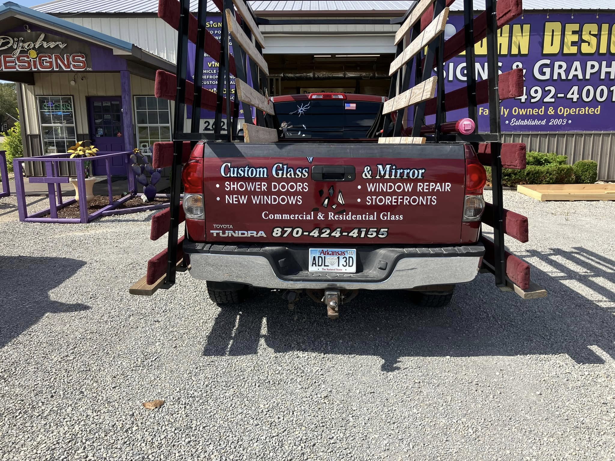 Custom Glass & Mirror branded red Toyota Tundra pickup truck with full back window vinyl graphics.