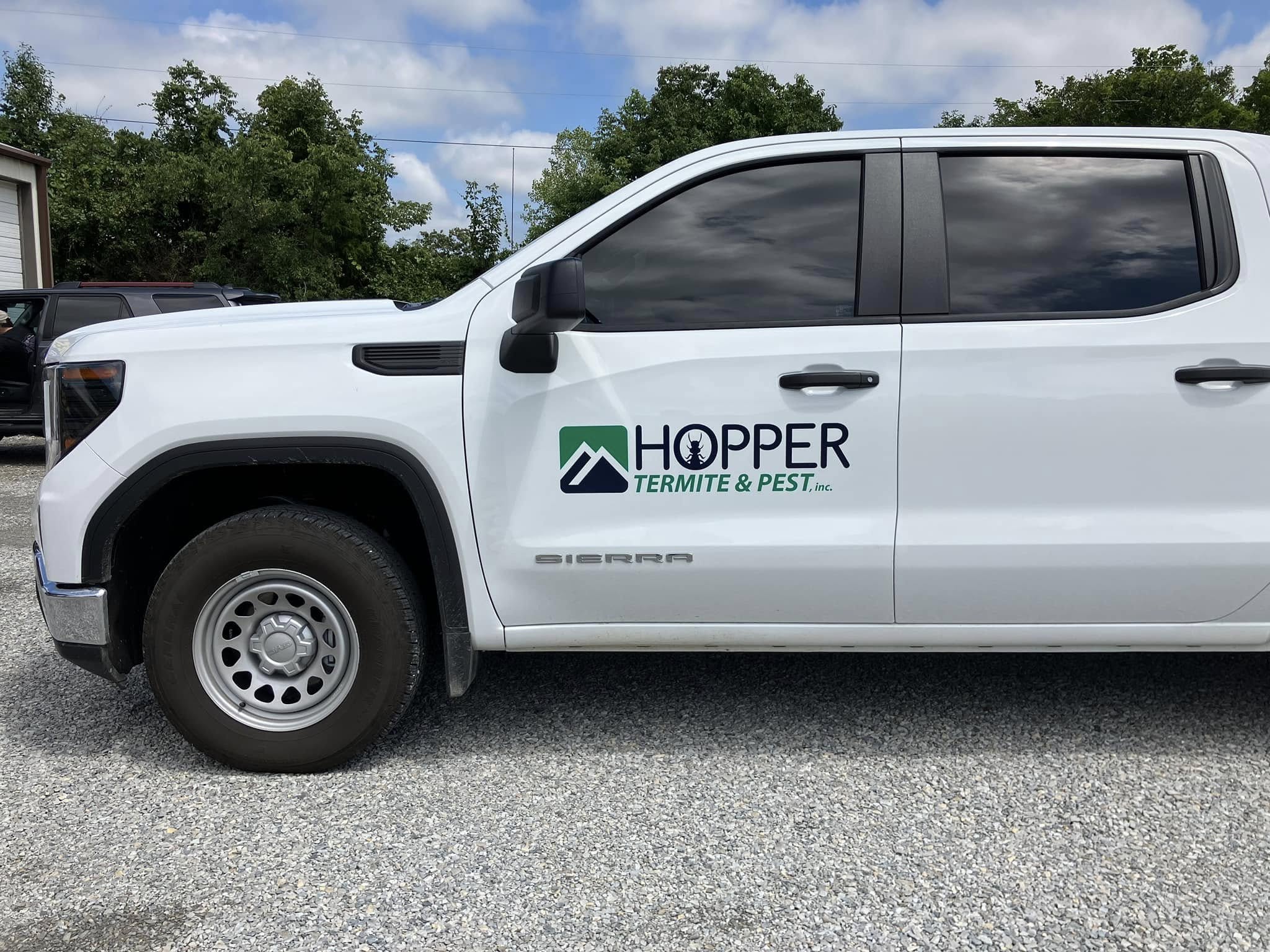 White GMC Sierra pickup truck with Hopper Termite & Pest Inc. vinyl graphics
