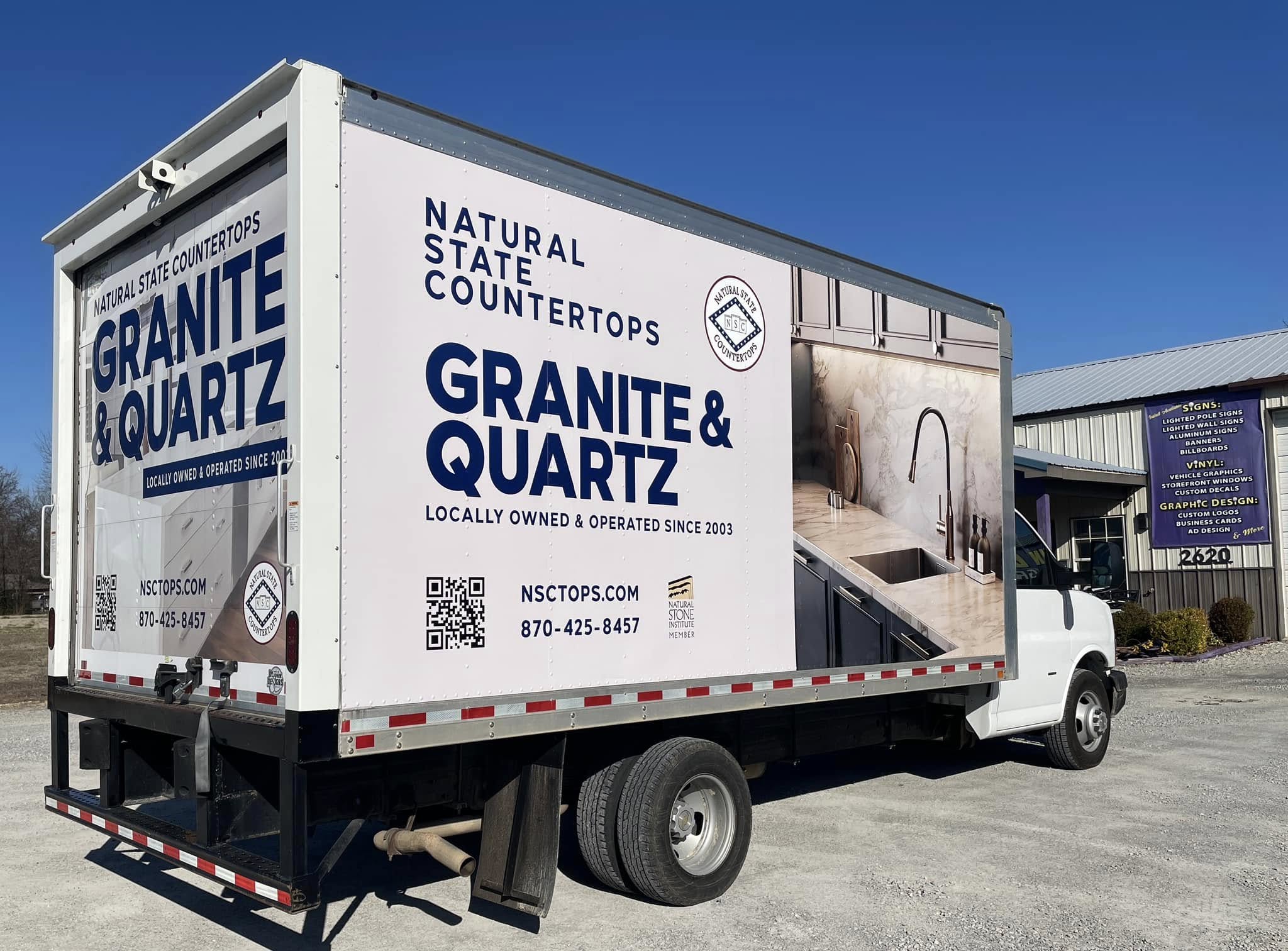 Full box truck wrap for Natural State Countertops, featuring granite and quartz advertisements with QR codes.