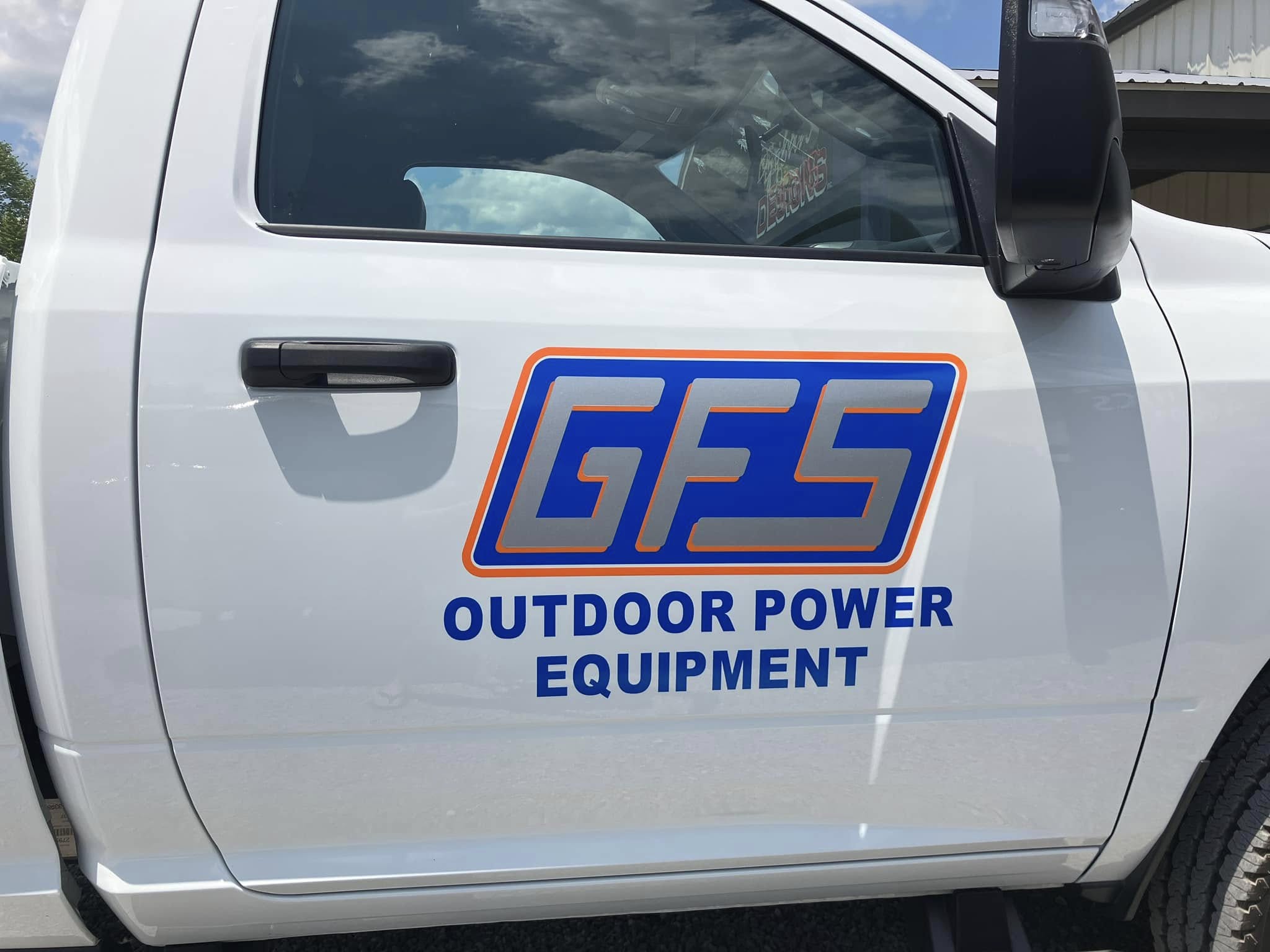 White business truck with blue and orange 'GFS Outdoor Power Equipment' vinyl graphics on the door