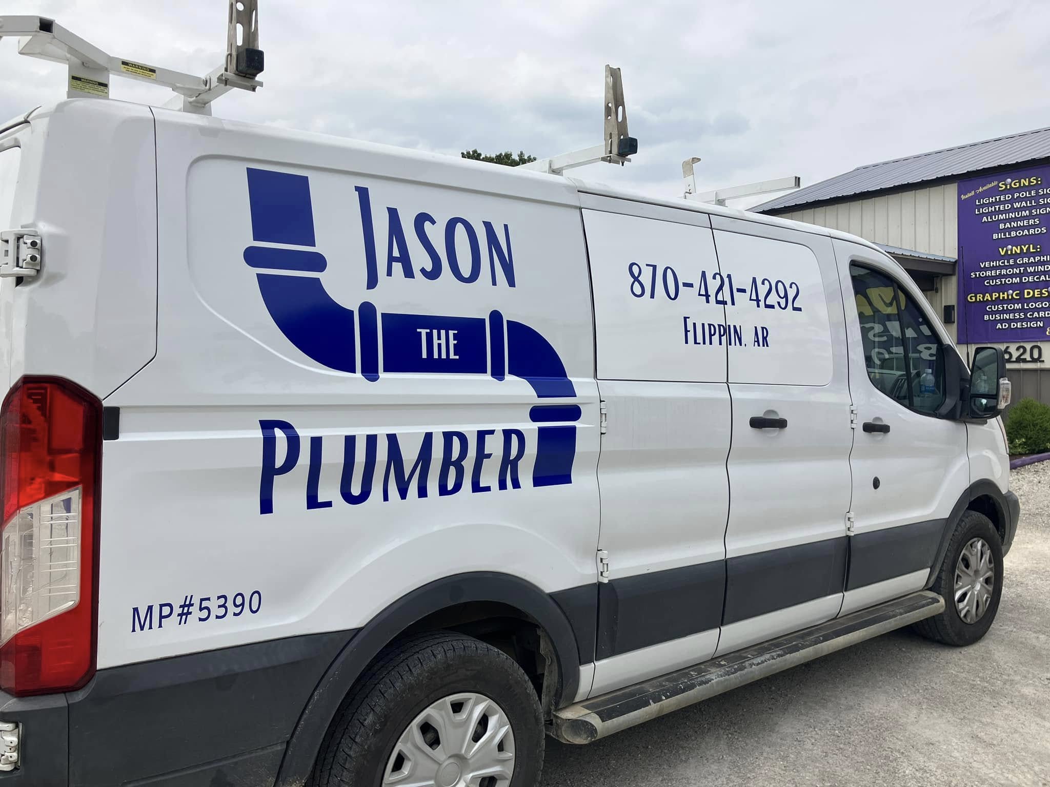 Custom blue vinyl graphics for Jason The Plumber on the side of a white Ford Transit van.