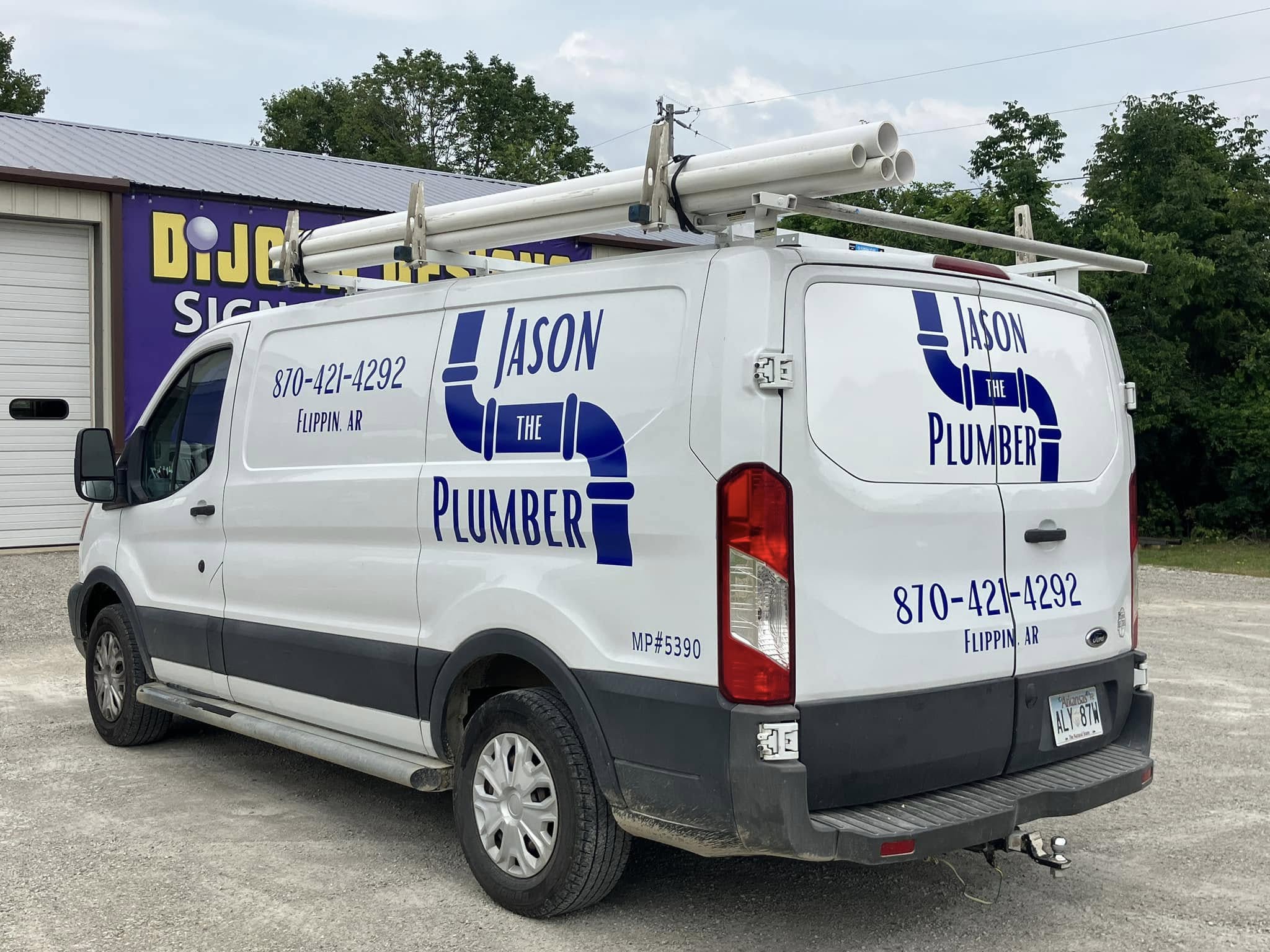 Custom blue vinyl graphics for Jason The Plumber on white work van with pipe-shaped logo.