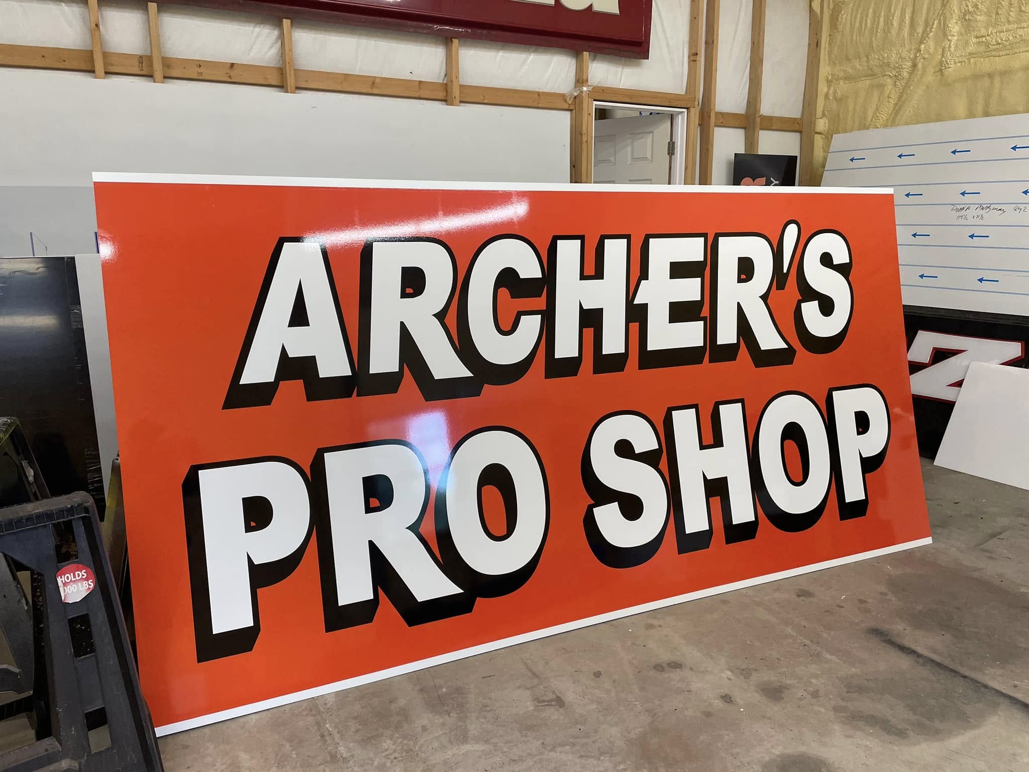 Archer's Pro Shop bright orange and white storefront building sign.