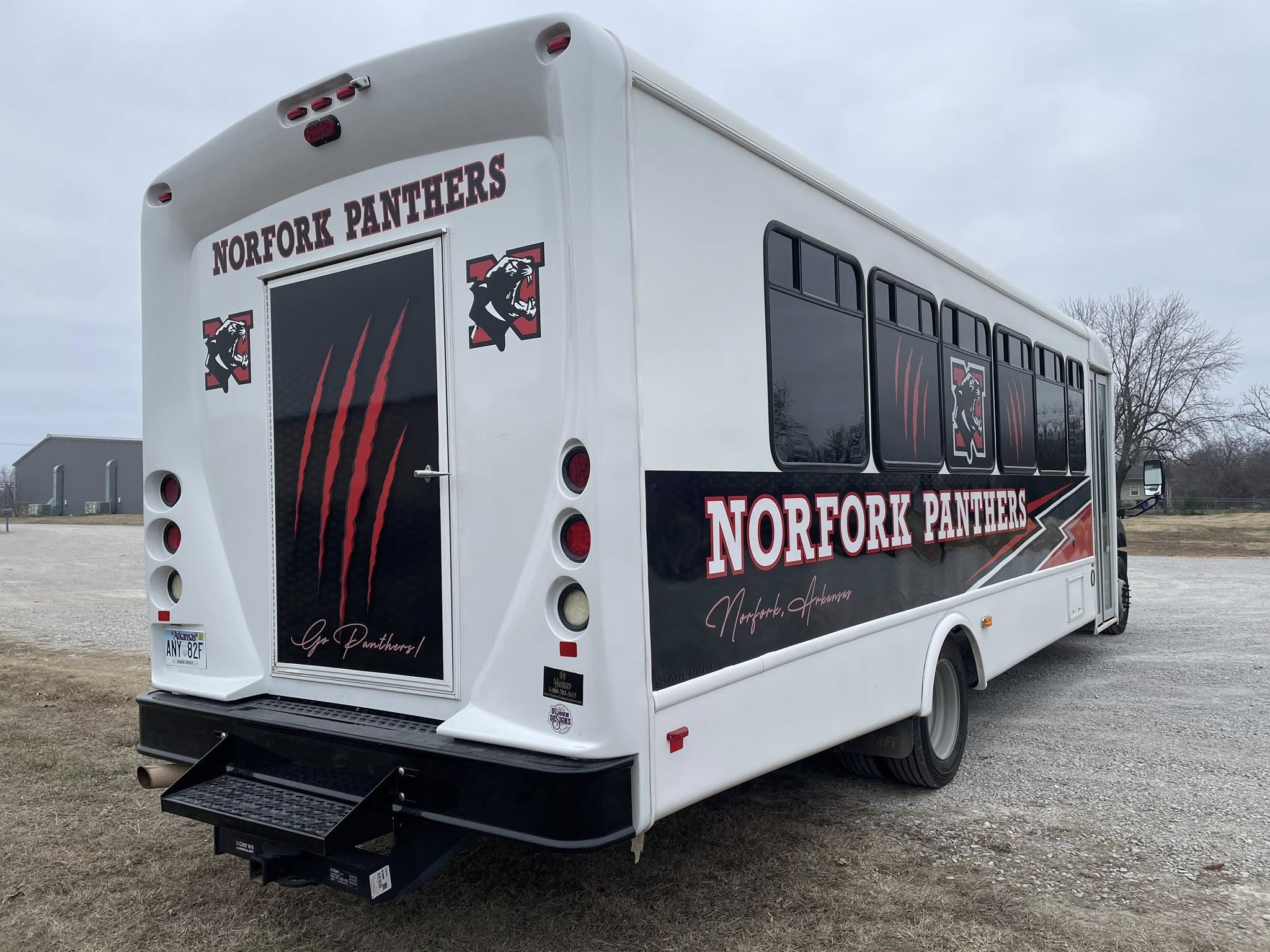 Custom full wrap for Norfork Panthers school bus with red and black graphics of a panther.