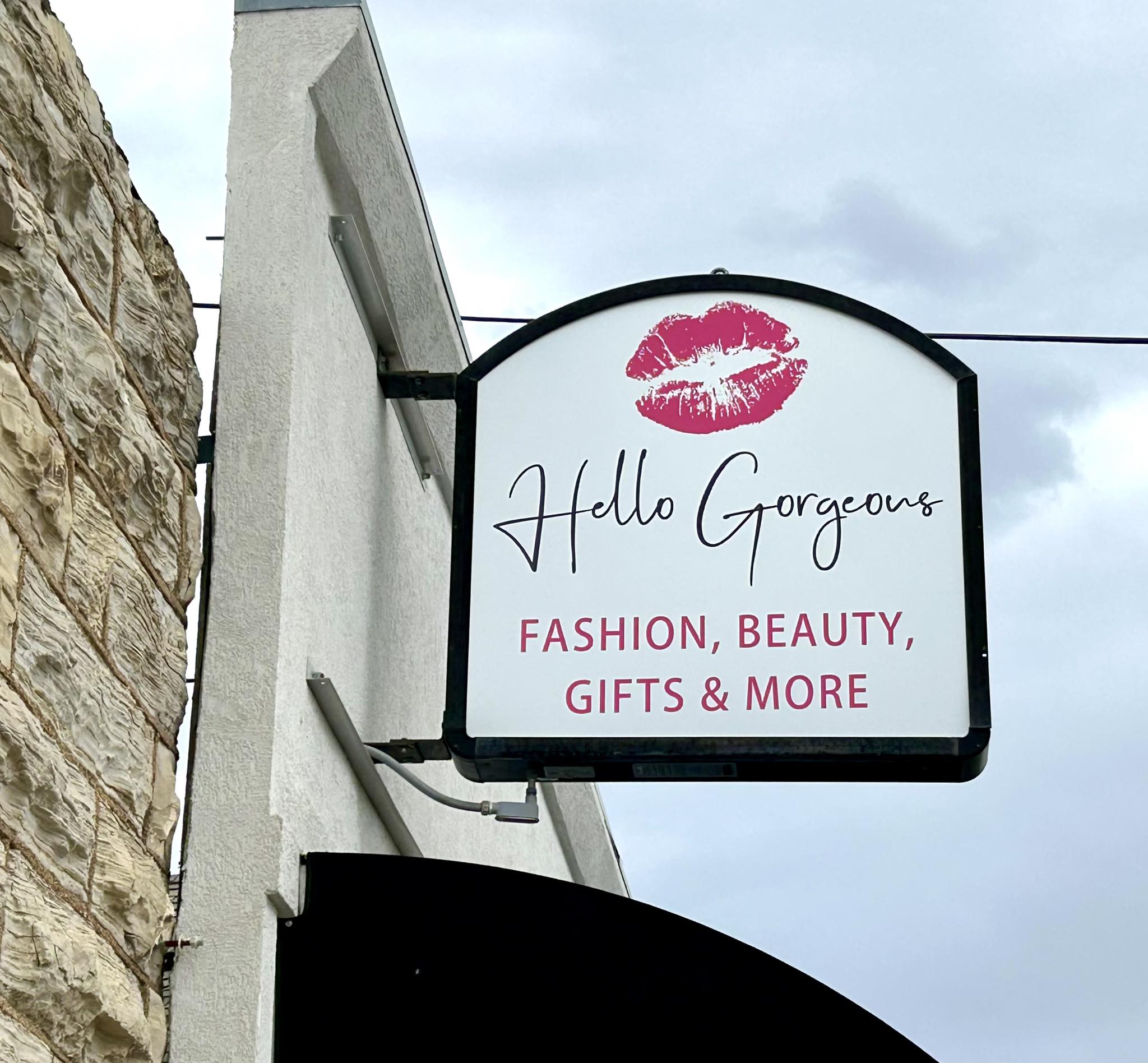 Hello Gorgeous fashion beauty gifts and more storefront blade sign with kiss logo.