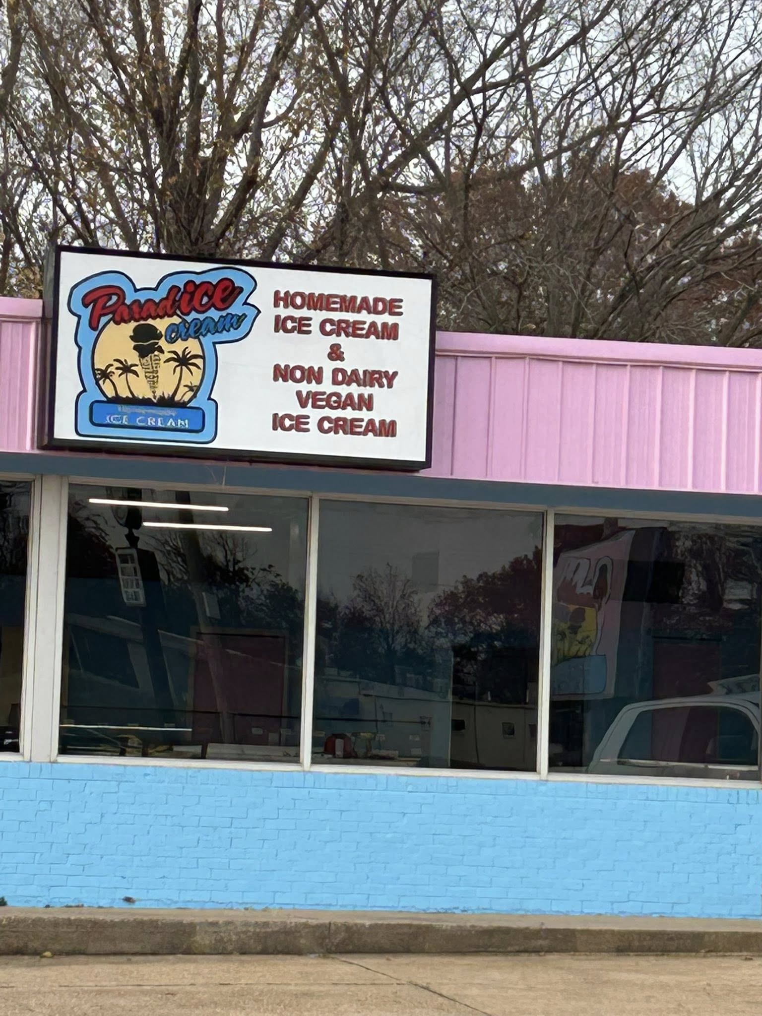 Lighted box sign with a custom logo for Paradise Cream ice cream shop on a pink building.