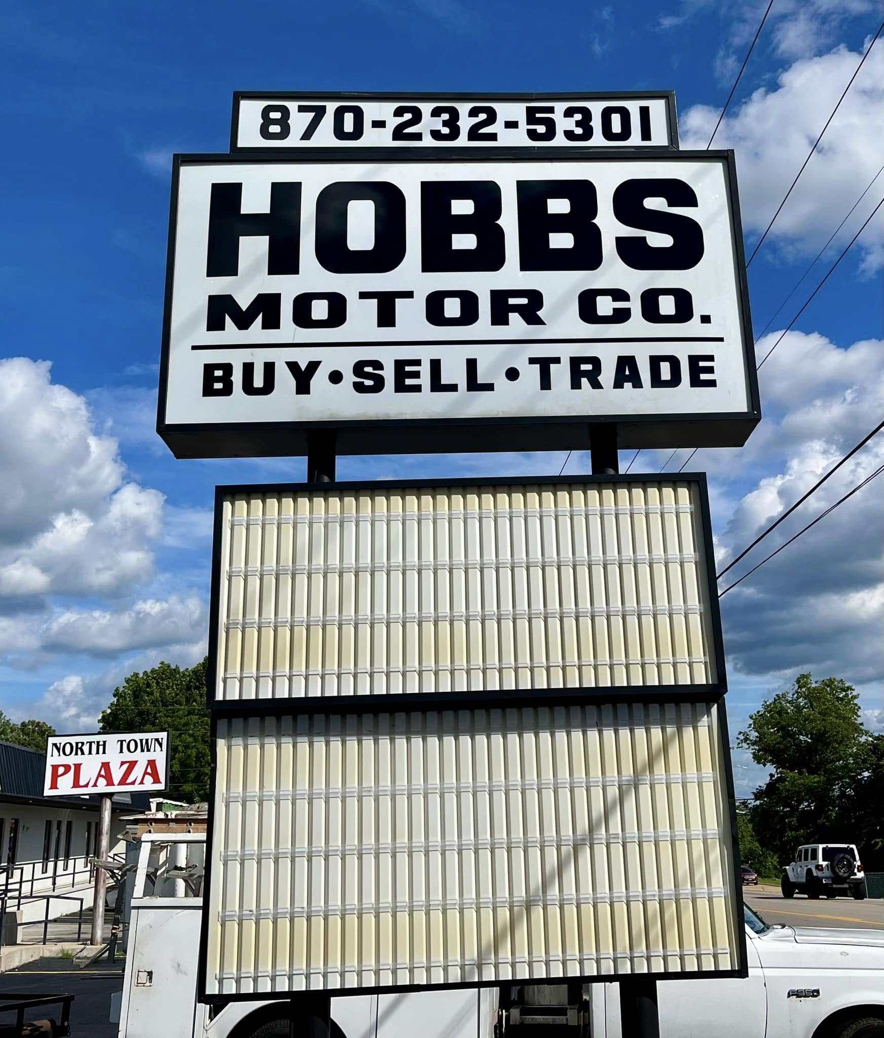 White pylon sign with Hobbs Motor Co. black text and changeable message board below.