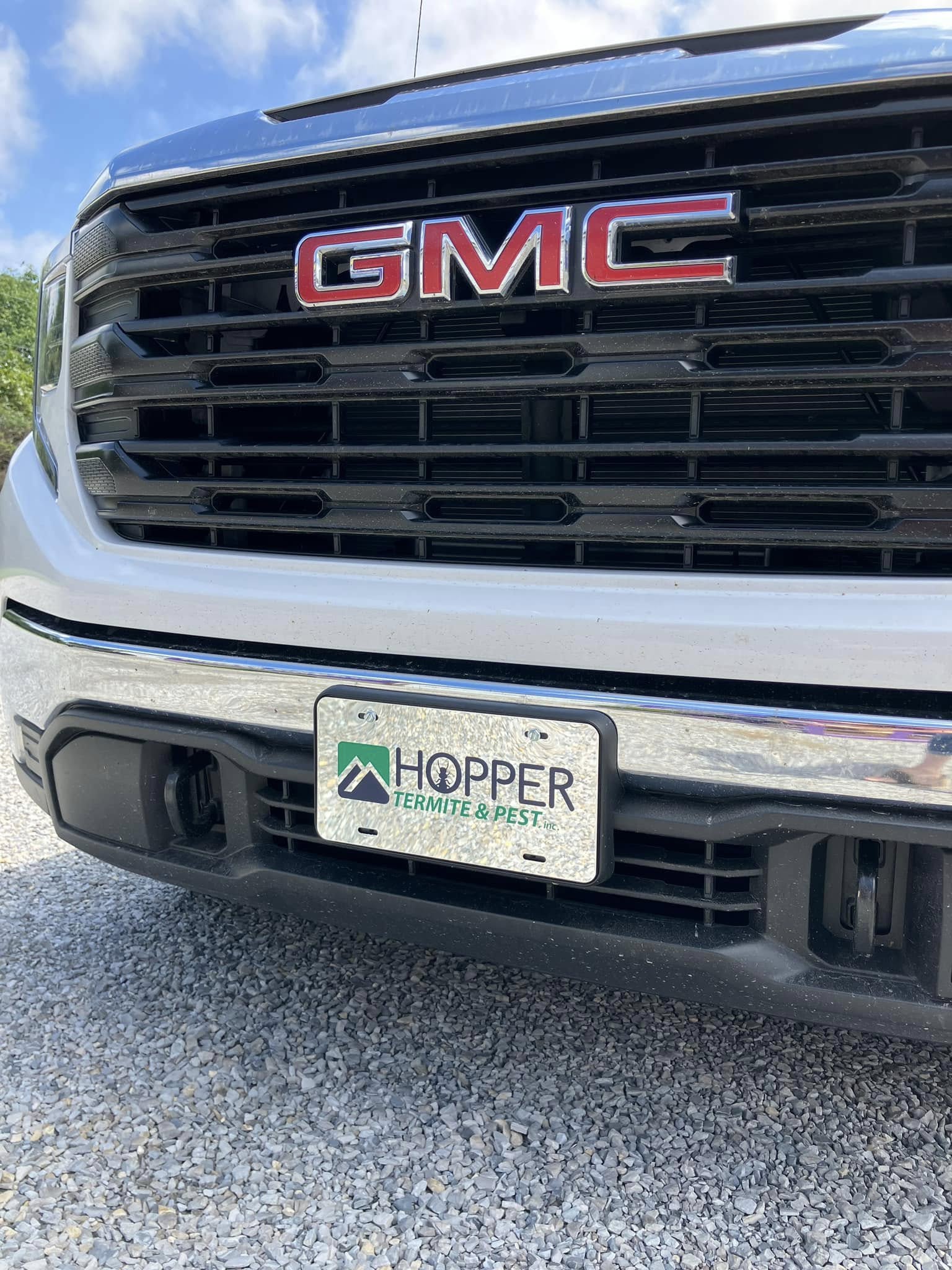 Custom license plate for Hopper Termite & Pest, Inc. on a white GMC truck, featuring company logo.