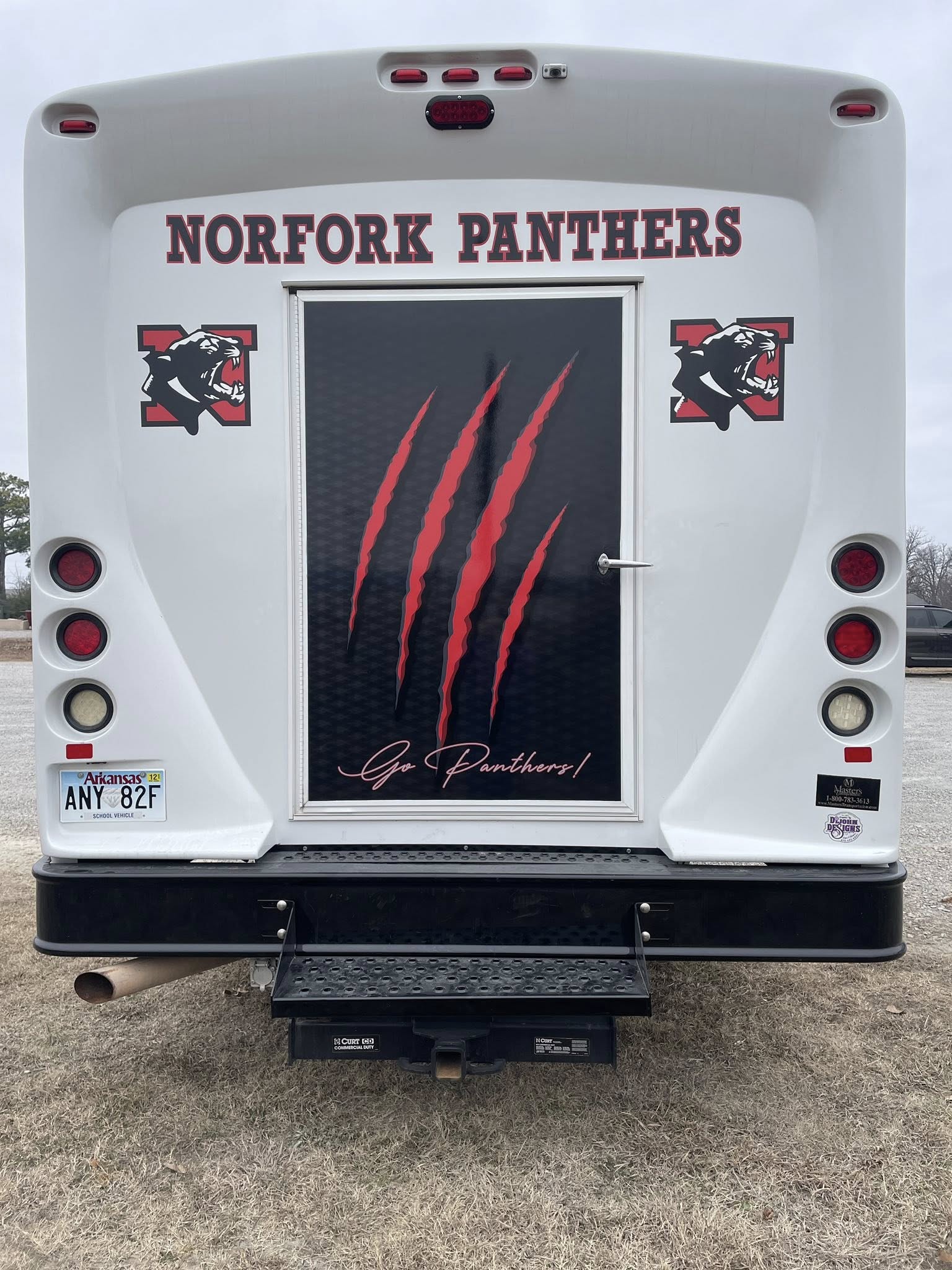 Custom vehicle graphics for a white Norfork Panthers school bus with red panther scratch marks