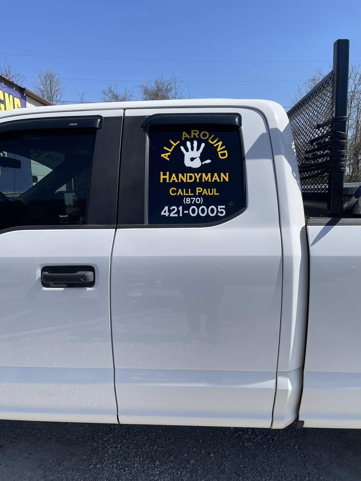 White pickup truck with black and yellow vinyl window graphics for All Around Handyman