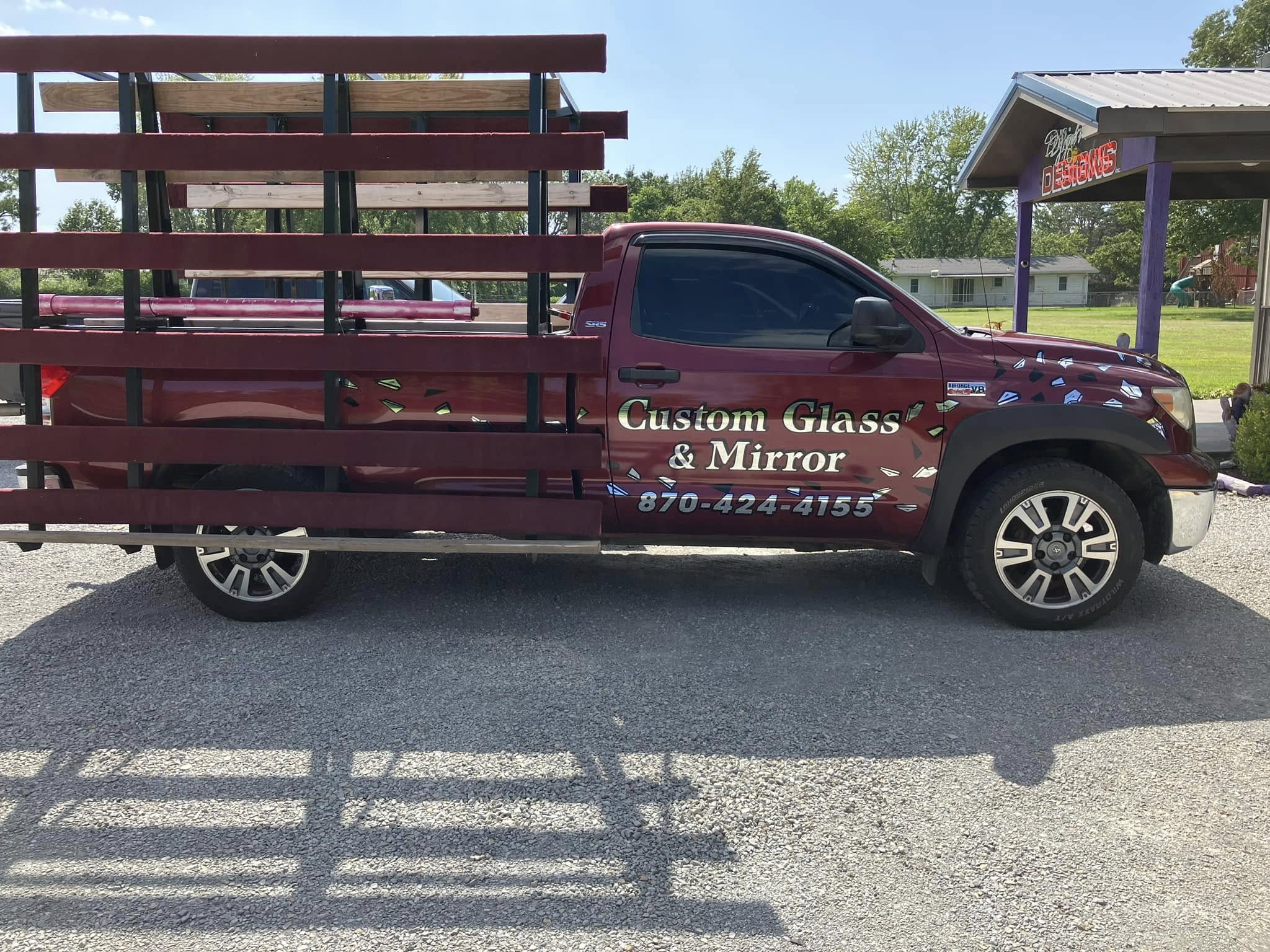 Custom Glass & Mirror branding with shattered glass graphics on a maroon glass-hauling truck.