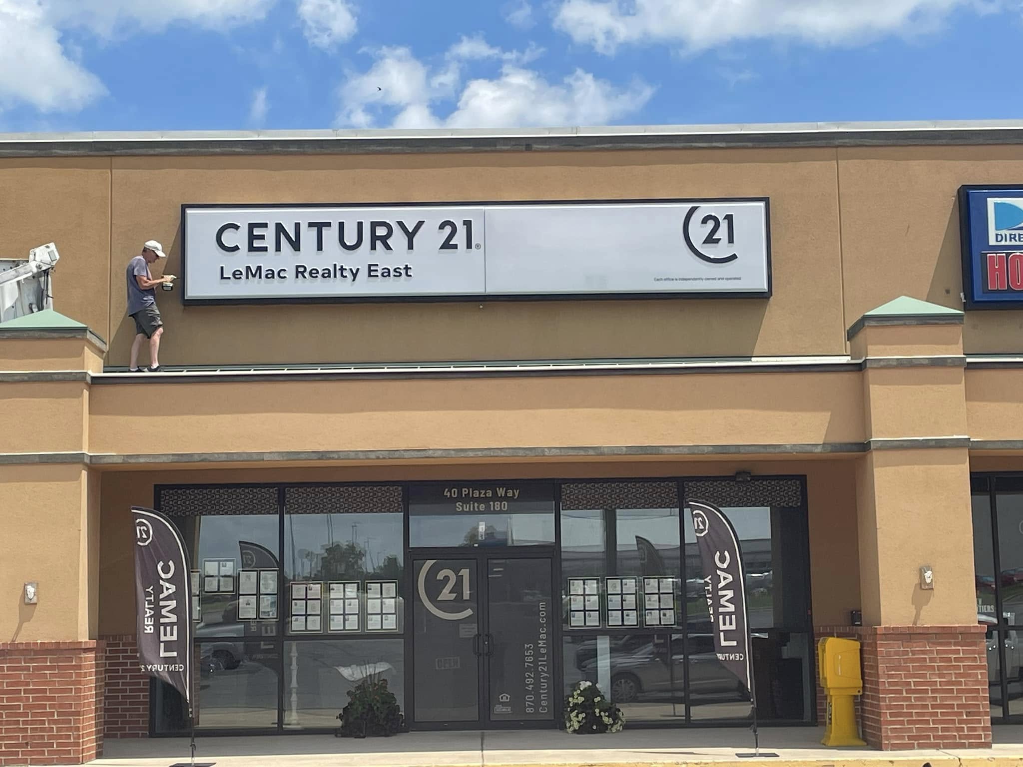 Installation of channel letter sign for Century 21 LeMac Realty East storefront with accompanying window graphics.