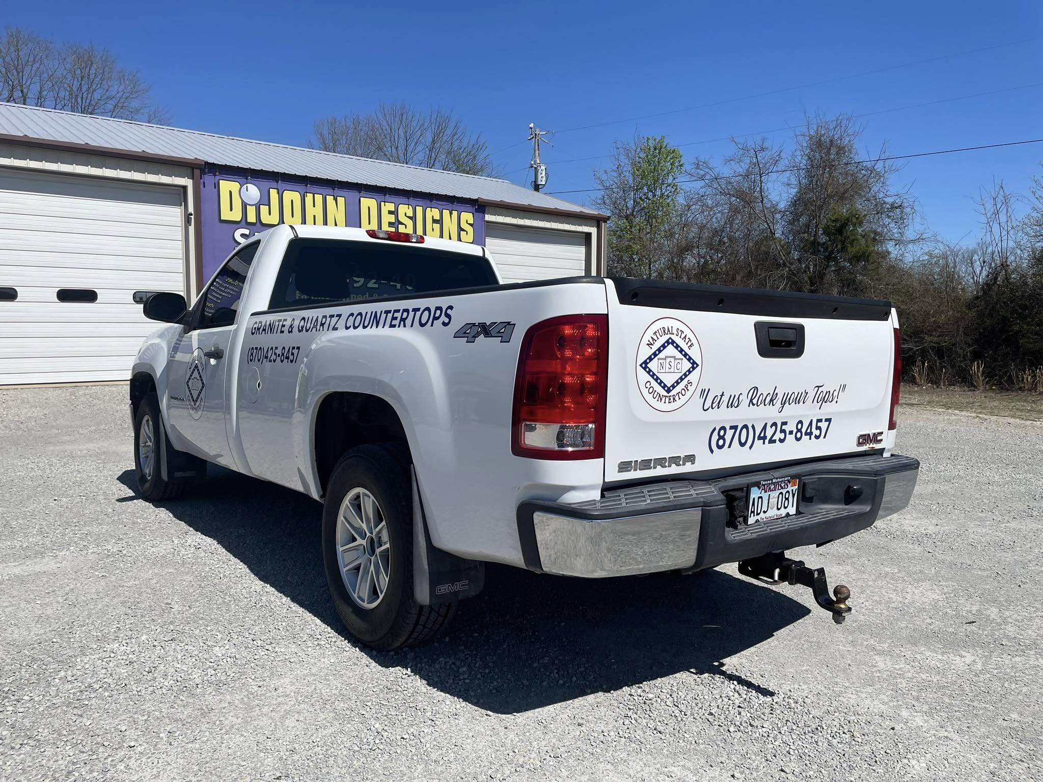 White GMC Sierra pickup truck with custom vinyl graphics for a granite and quartz countertop business.