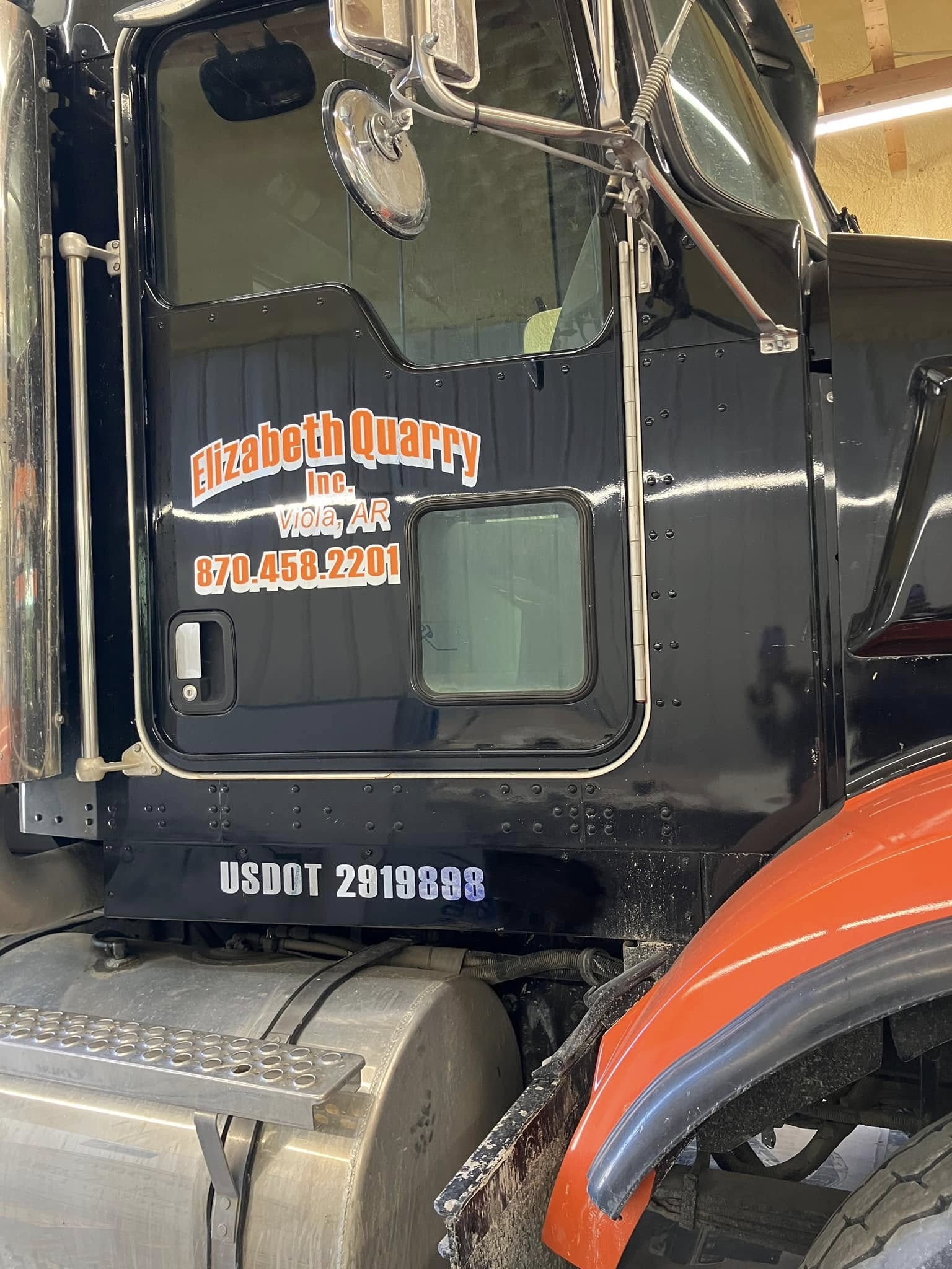 Orange and white vinyl lettering on black semi-truck door for Elizabeth Quarry Inc.