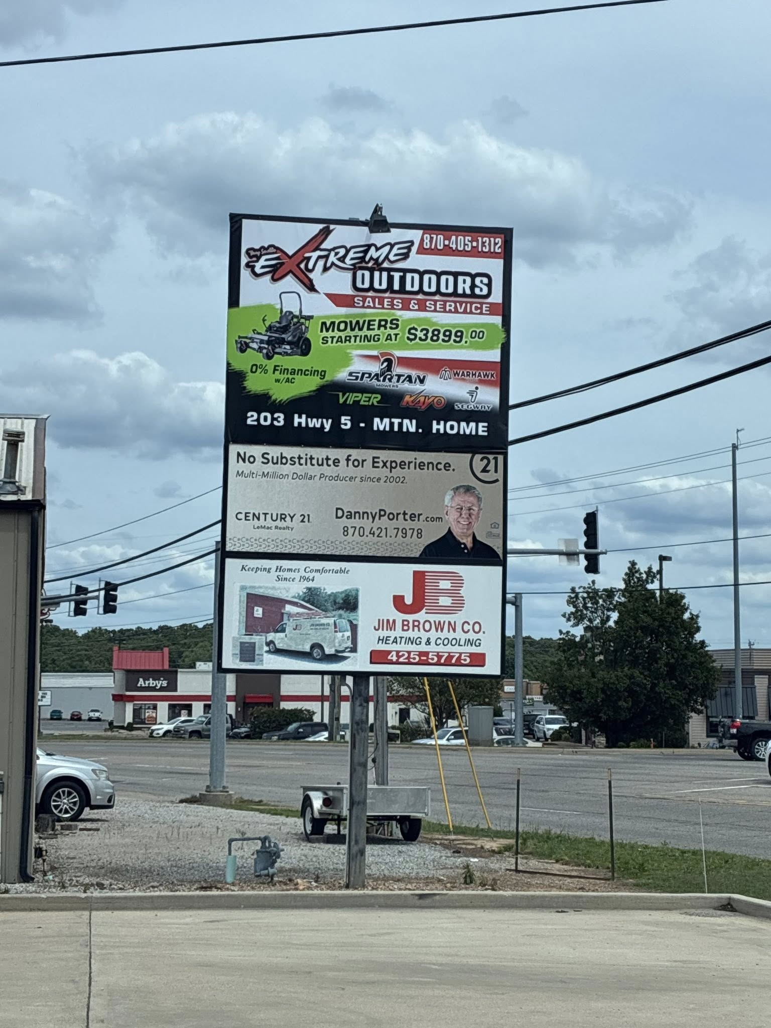 Large outdoor pylon sign advertising Extreme Outdoors mower sales, Century 21 Century 21 Real Estate, and Jim Brown Co. Heating & Cooling.